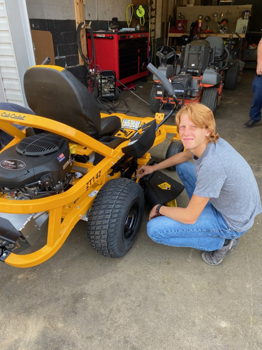 person working on a riding mower